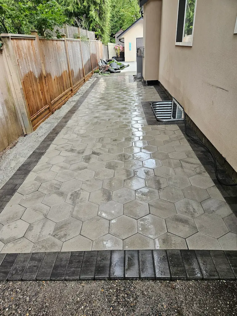 Concrete walkway and patio running through a landscaped Langley backyard