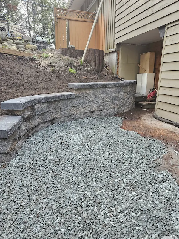 Natural stone retaining wall and steps tied into a Langley garden